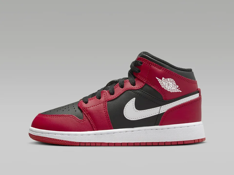 Red, black and white Air Jordan 1 Mid on a grey studio ground
